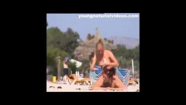 Lesbian couple kissing and groping on beach
